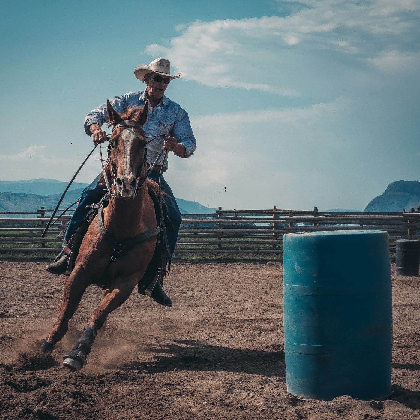 A barrel racer and horse wrapped tight around a barrel.